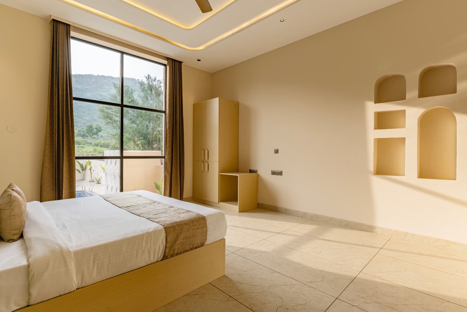 Bright bedroom with a large window overlooking the pool and hills