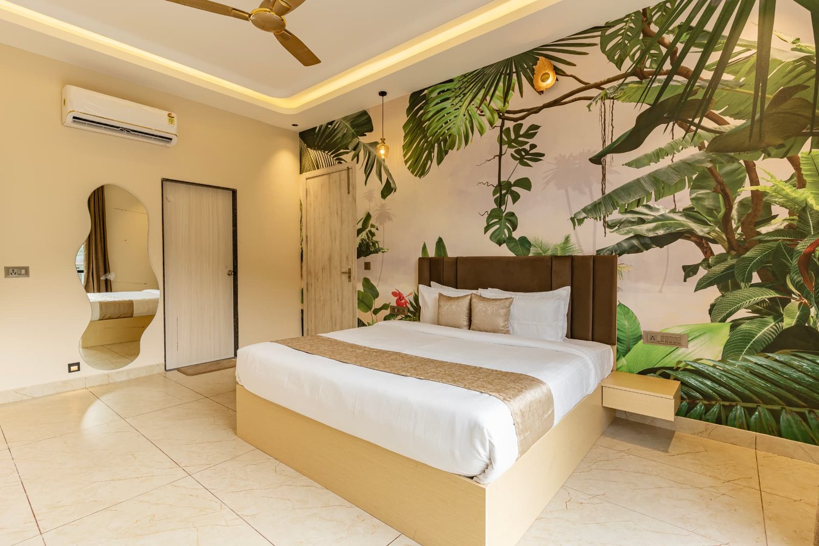 Air-conditioned bedroom with king bed and tropical mural