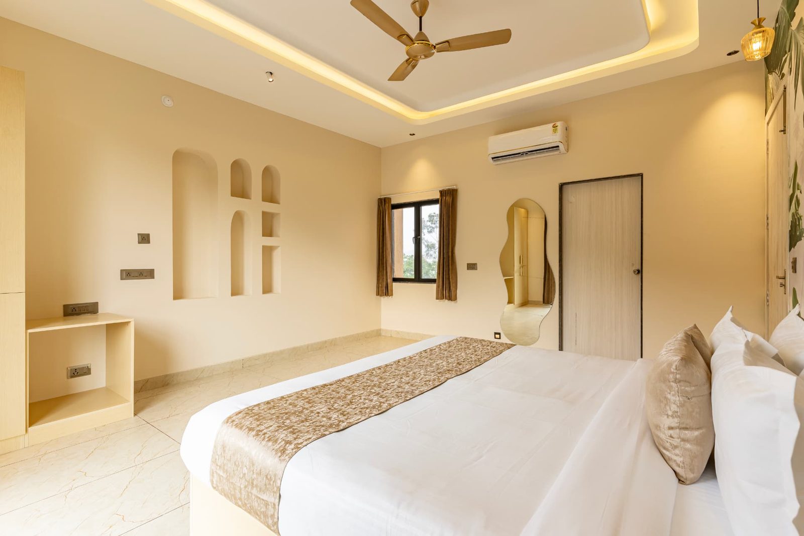 Spacious bedroom with arched wall niches, wardrobe and marble flooring