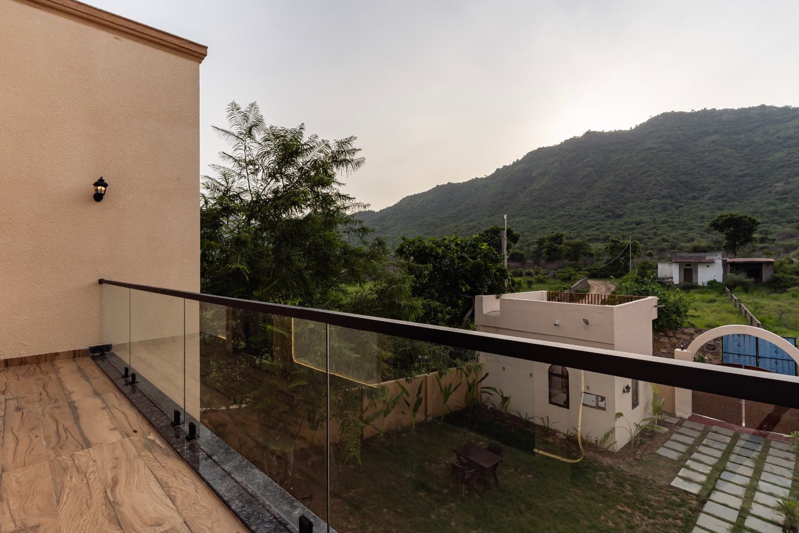 Glass-railed terrace overlooking the garden and green hills
