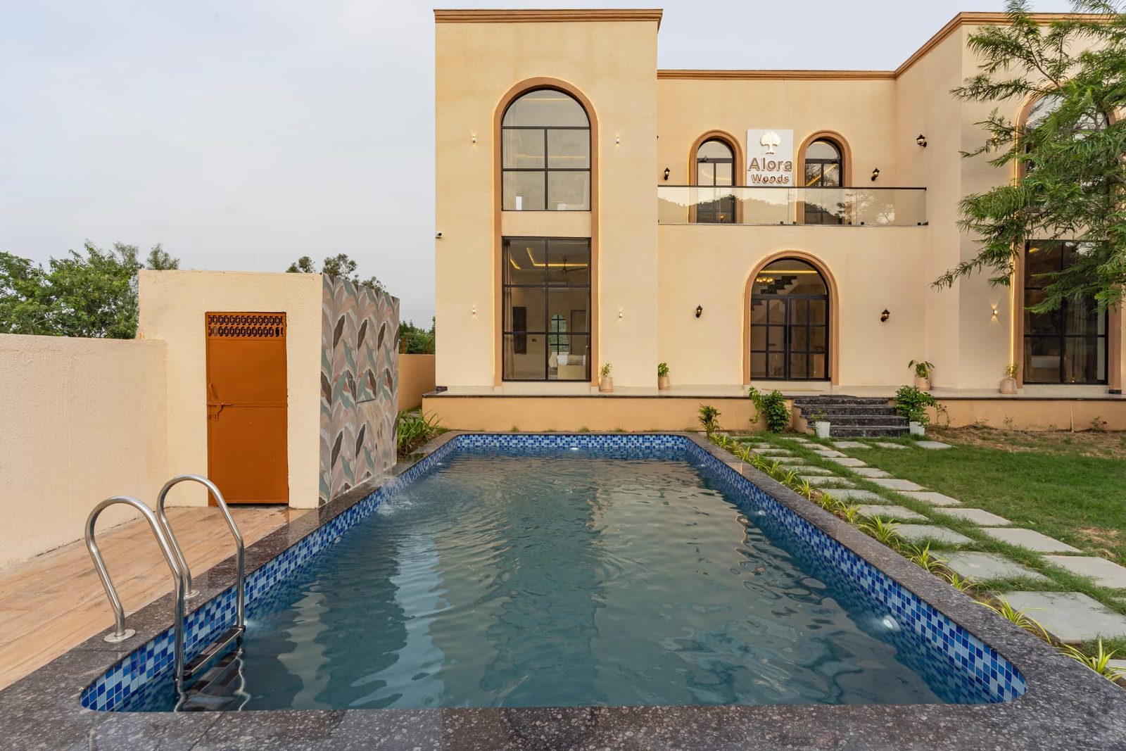 Private swimming pool facing the arched facade of Alora Woods Villa, Udaipur